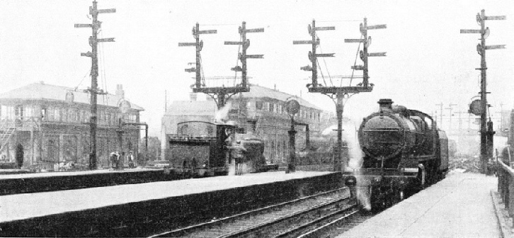 THE OLD AND THE NEW SYSTEMS. This view of Brighton station shows the semaphore-arm signals which were formerly in use. Compare it with the view below, which depicts the new colour-light signals that now control the same lines.