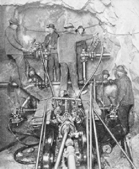 A working face, showing a powerful drilling machine in action during the boring of the great Cascade Tunnel
