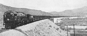 A SEVENTY-WAGONS FREIGHT TRAIN on the Southern Pacific Railroad being hauled by one of the large oil-fired 4-8-0+0-8-4 articulated engines of the “4100” class