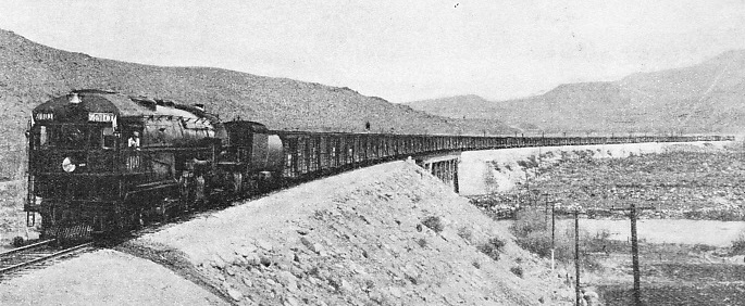 A SEVENTY-WAGONS FREIGHT TRAIN on the Southern Pacific Railroad being hauled by one of the large oil-fired 4-8-0+0-8-4 articulated engines of the “4100” class