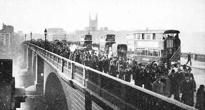 Business people streaming over London Bridge in the morning towards the City after they have left London Bridge Station