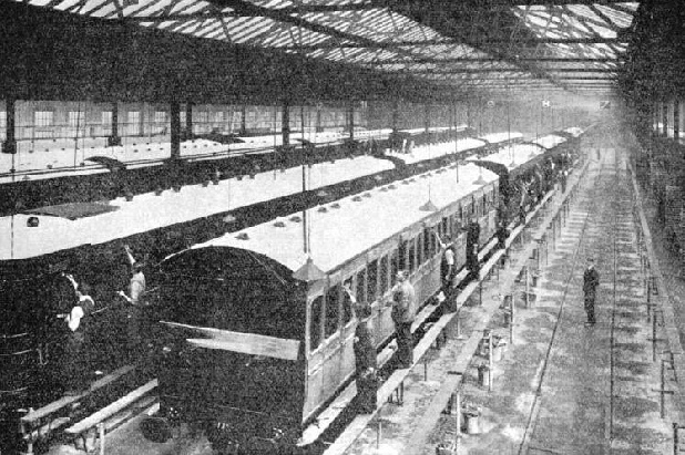 Rows of coaches owned by the Southern Railway receiving a fresh coat of paint in the Company's works at Lancing, Sussex