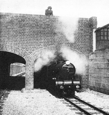 A MINIATURE BRIDGE carries the road over the double track of the Romney, Hythe and Dymchurch Railway