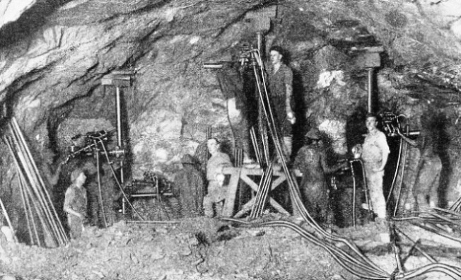 A BATTERY OF DRILLS photographed in action on the face of a tunnel at Randfontein, South Africa